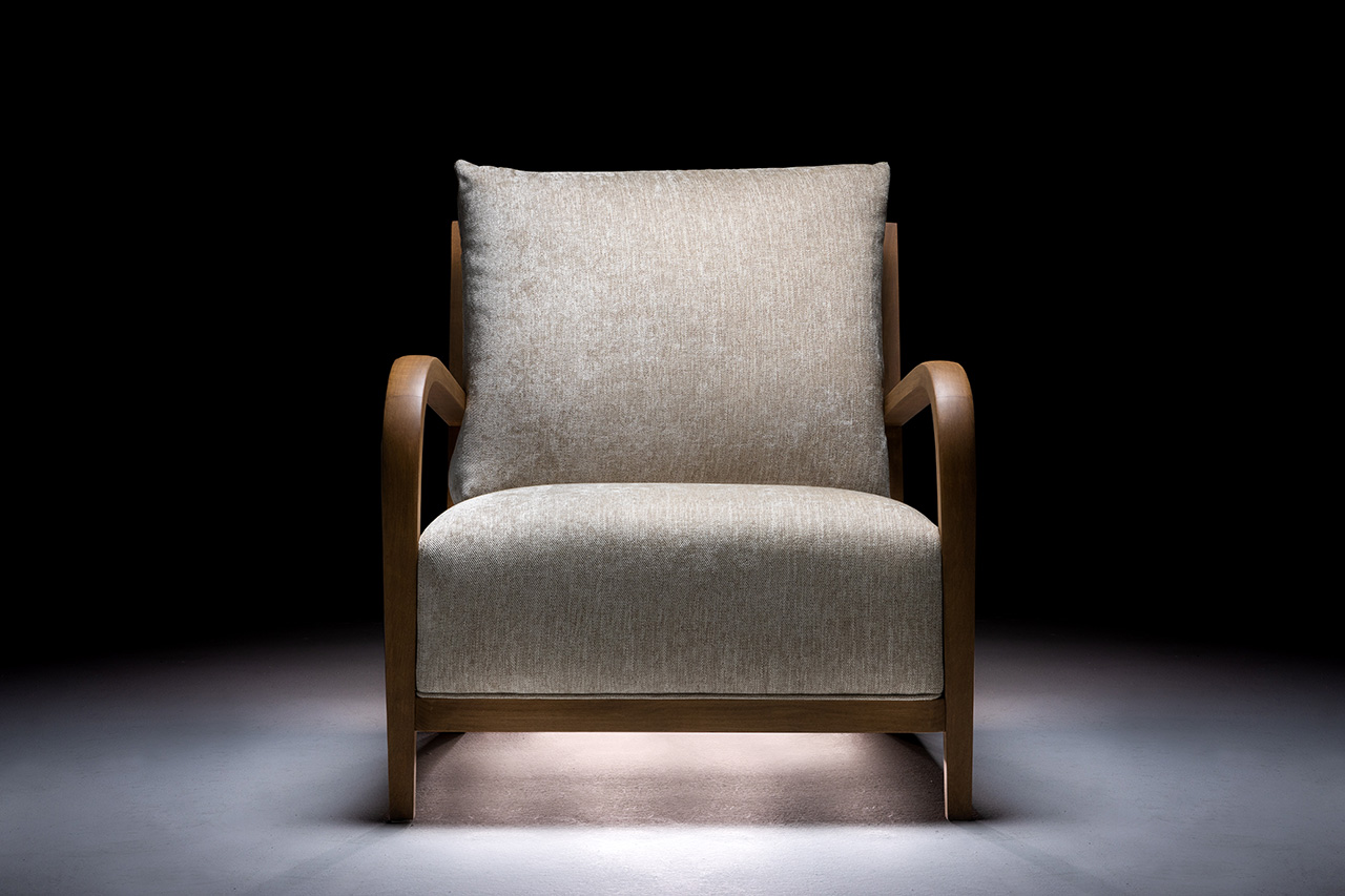 Poltrona design artigianale con seduta e schienale in tessuto per un ambiente elegante.